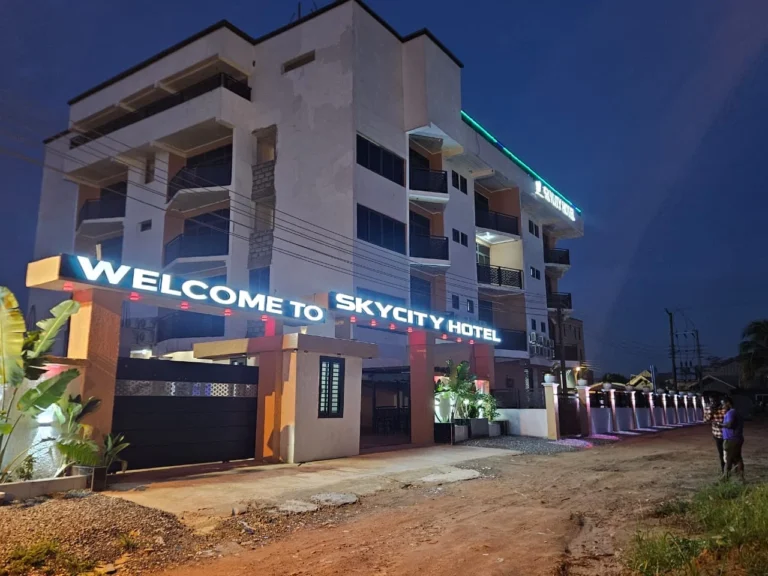 Illuminated Welcome to Skycity Hotel sign above the main gate at dusk