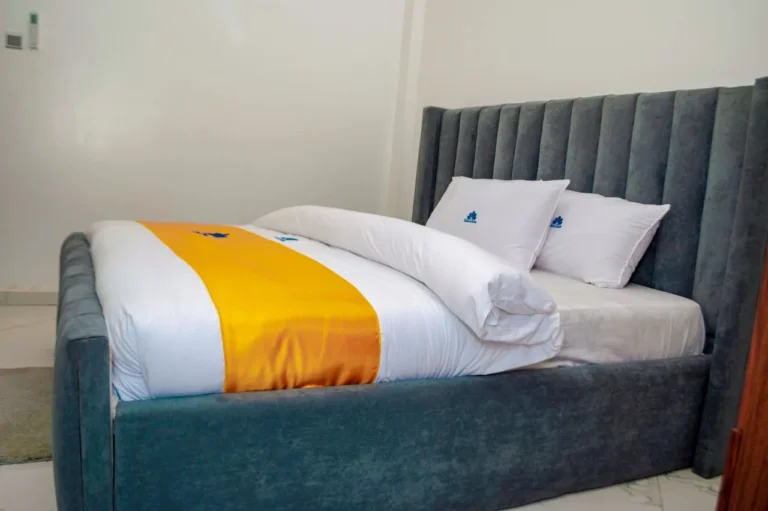 Grey upholstered headboard and gold bed runner at Skycity Hotel