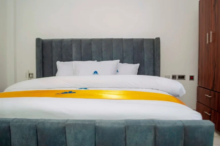 Room with grey upholstered king bed at Skycity Hotel