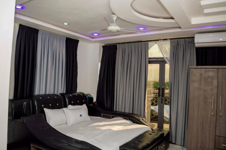 Spacious room with leather bed and balcony doors at Skycity Hotel