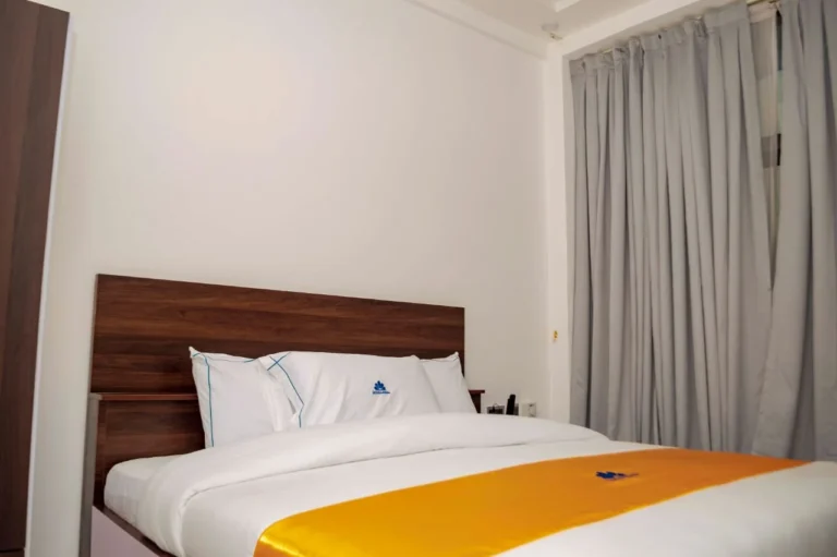Hotel room with wooden headboard and crisp white linen at Skycity Hotel